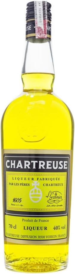 A bottle of Chartreuse liqueur with a bright yellow liquid visible through a clear glass bottle, featuring a black and gold label with the brand name 'Chartreuse' in white text.